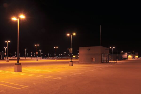 Empty parking lot with street lights at night.