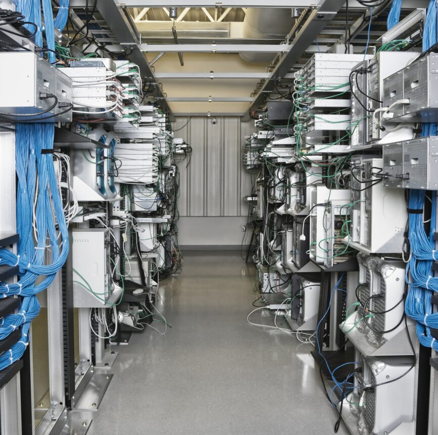 Server room aisle showing computer servers and CAT 5 cables.