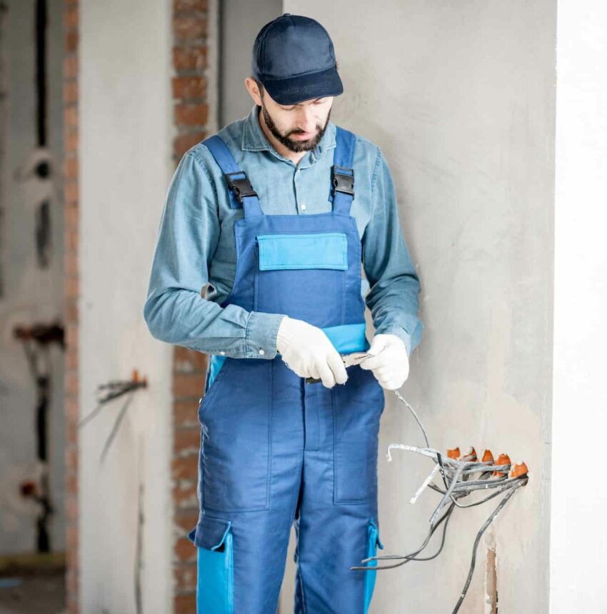 Electrician mounting wiring indoors