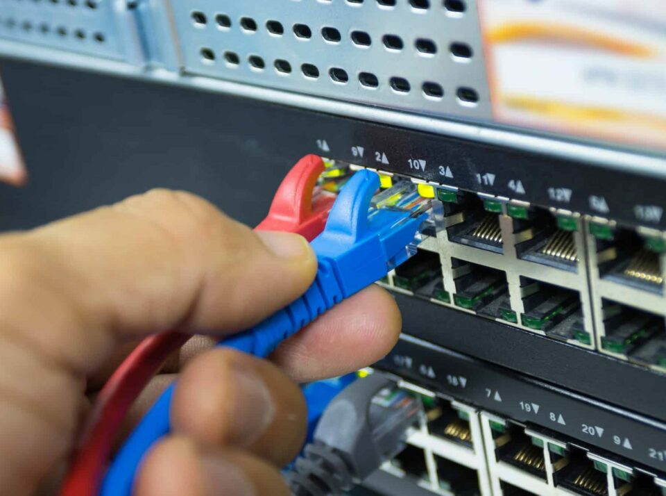 Hand of man holding The network cables to connect Lan port connect SFP module port in the Datacenter