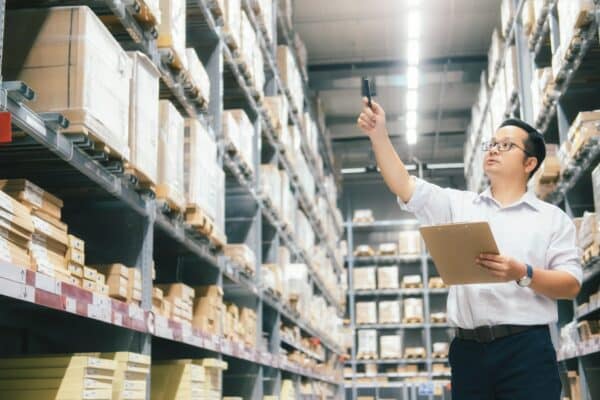 Man warehouse worker checking goods at warehouse.