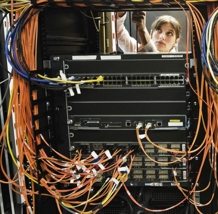 technicians working on a CAT 5 cable bundling system in a server room