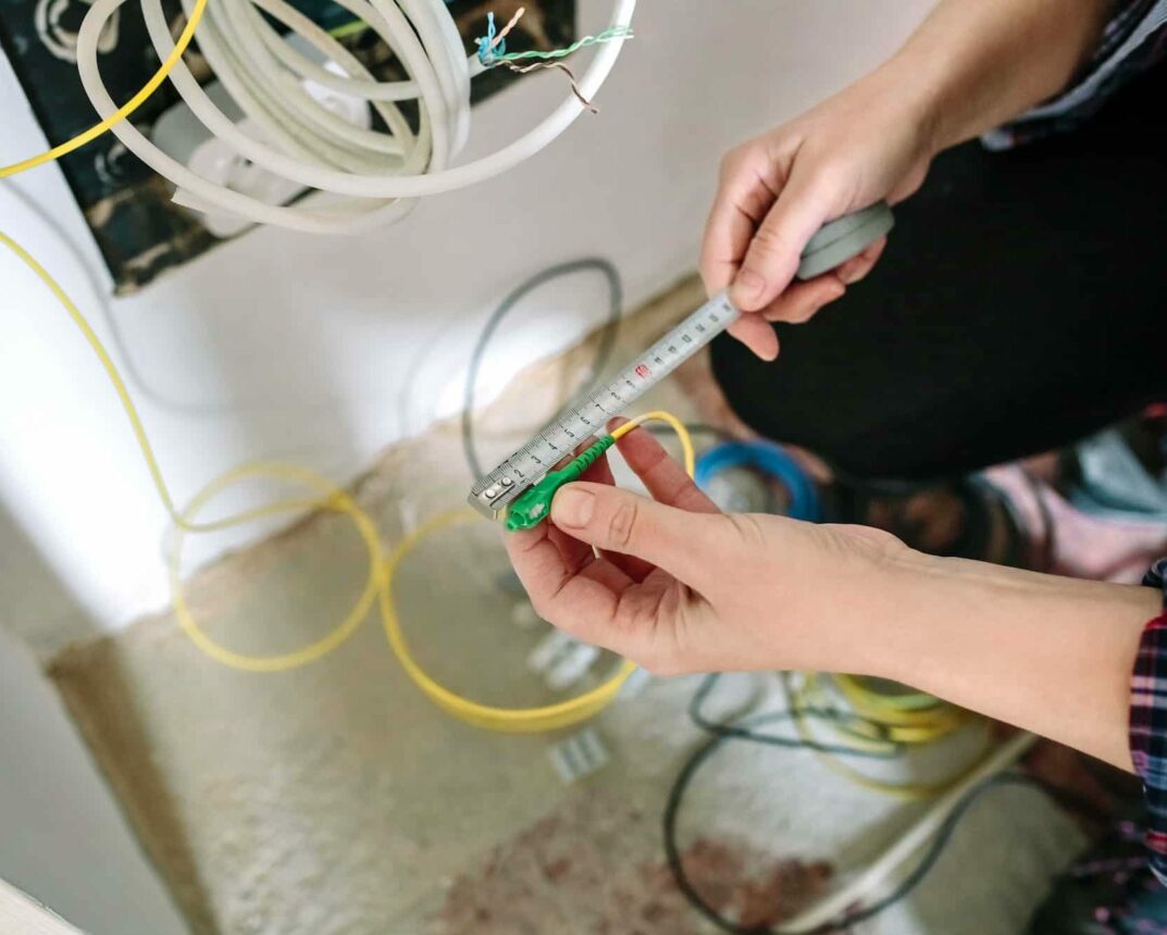 Telecommunications installer measuring fiber optic cable