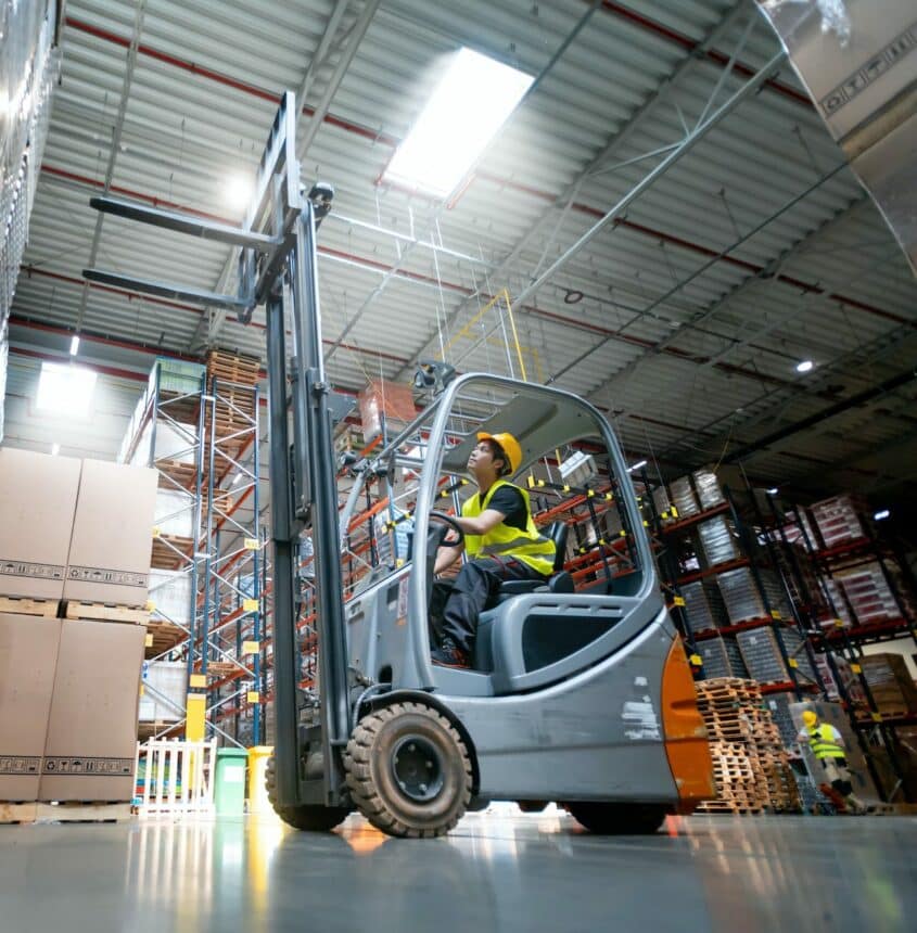 Warehouse worker operates a forklift