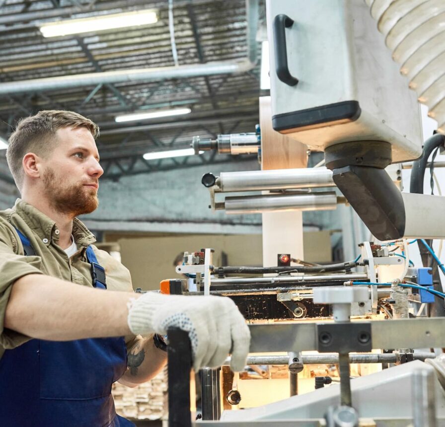 Young Factory Workers Operating Machine